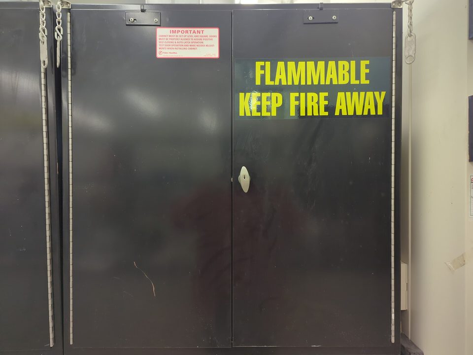 Closed flammable-storage cabinet marked FLAMMABLE KEEP FIRE AWAY