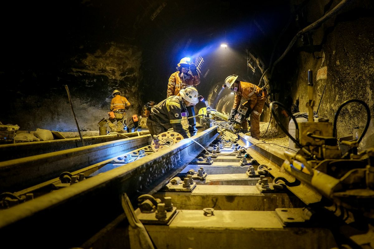 A crew working on rails inside a tunnel